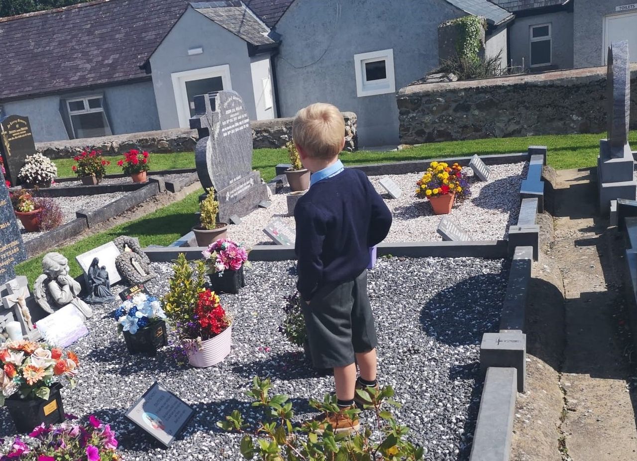 Telling daddy all about the first day at school – at his graveside