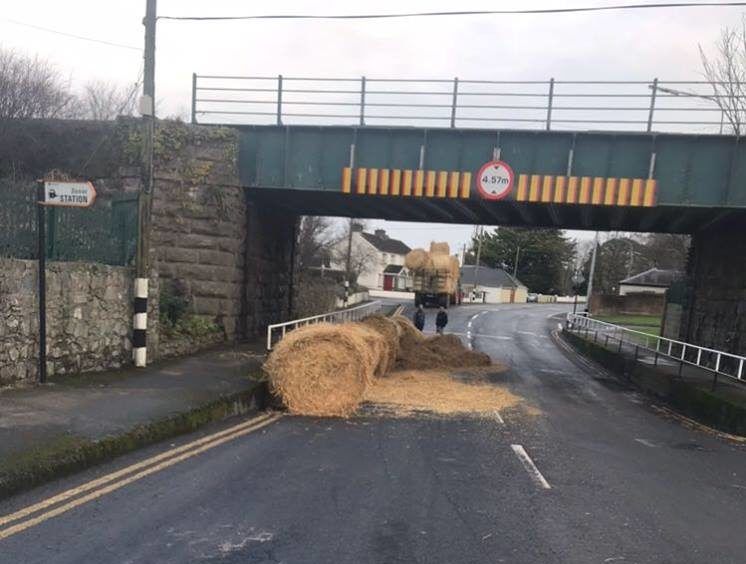The final 'straw': Tractor carrying bales strikes bridge