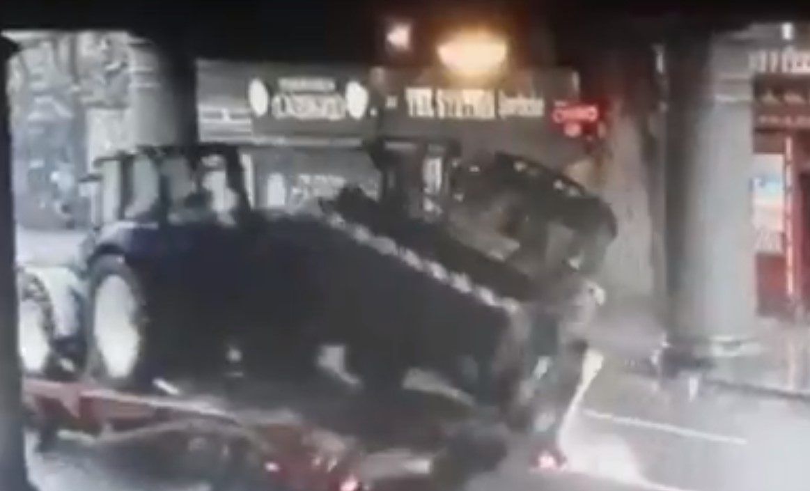 Video: Lorry carrying tractor and digger strikes bridge