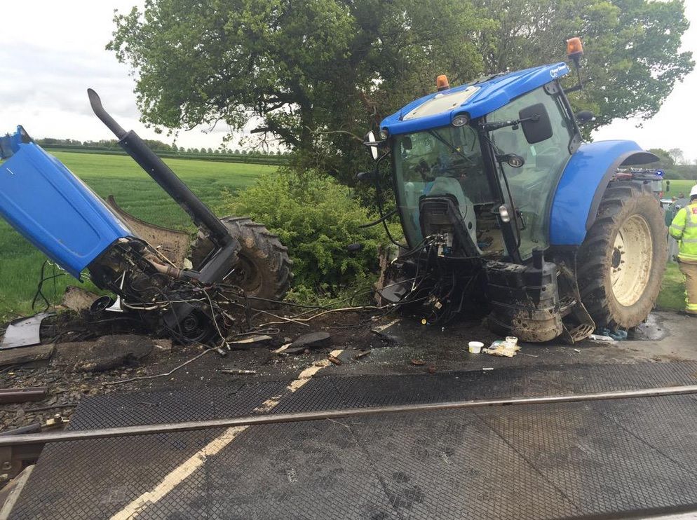 Tractor cut in two after it was hit by a train but the driver survives
