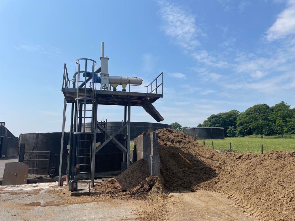 An electric motor pumps slurry to the separator (top) where the solids are extracted and the liquid is stored in the tank to the rear of the apparatus. The pile on the right is the dried manure which is very similar to compost