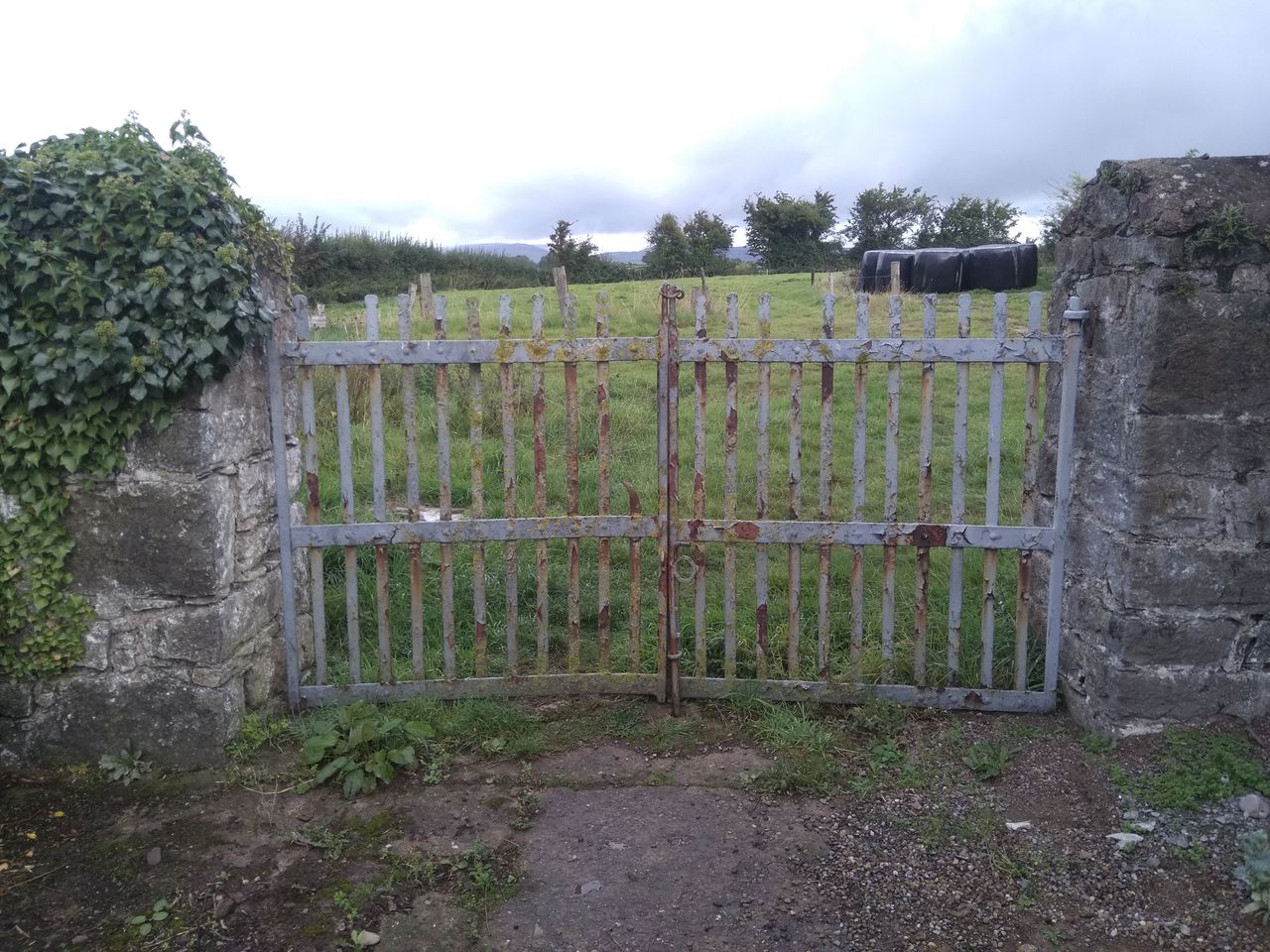 Farmyard wrought iron gates and stone piers preserved