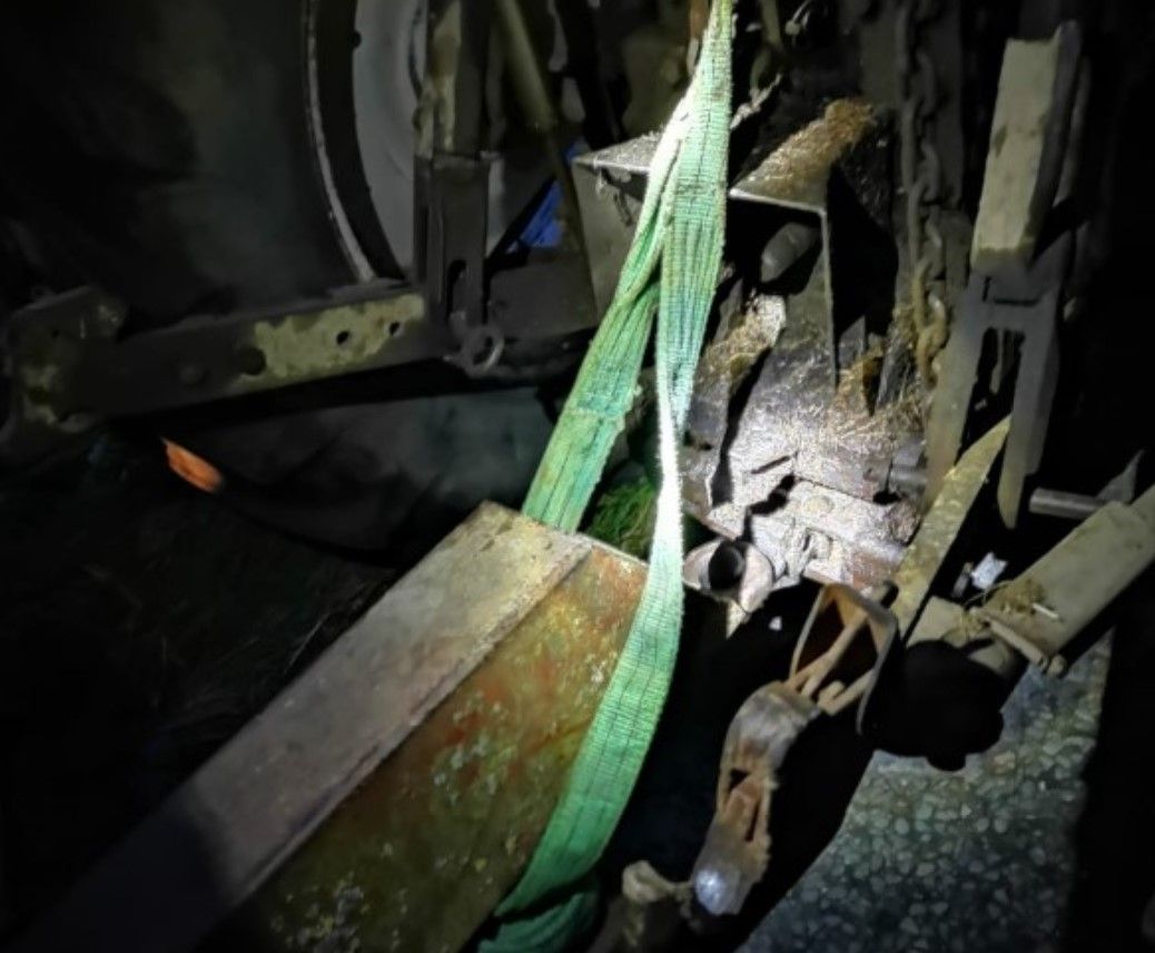 Trailer stopped 'supported to the tractor with a strap'